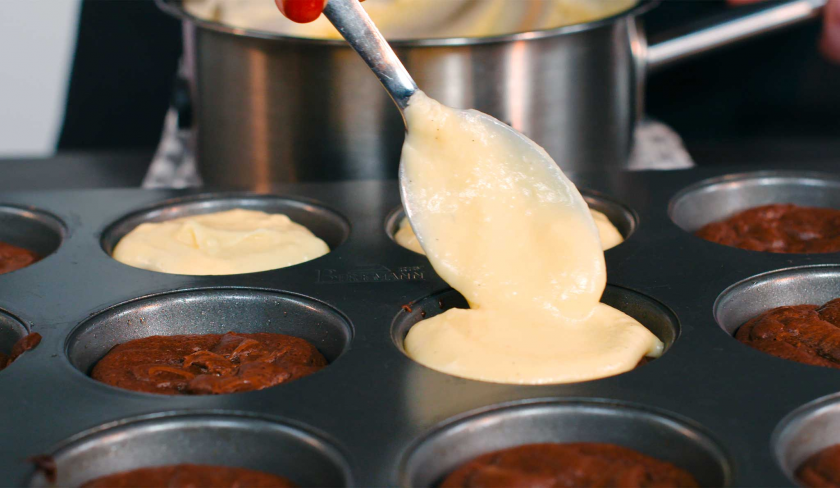 Die Vanillecreme für die Crème Brulée Brownie Törtchen wird auf den Küchlein verteilt.