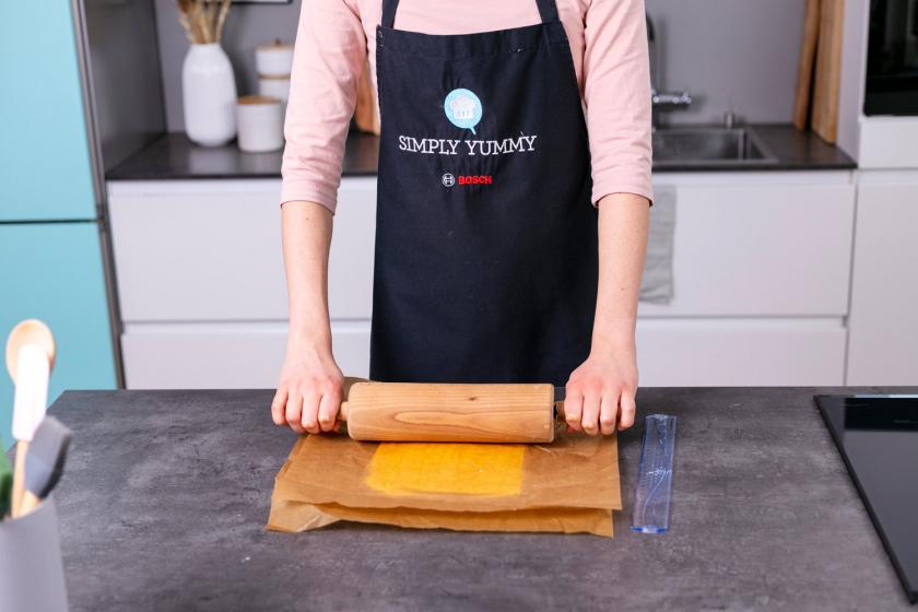 Butter wird zwischen zwei Stücken Backpapier ausgerollt.