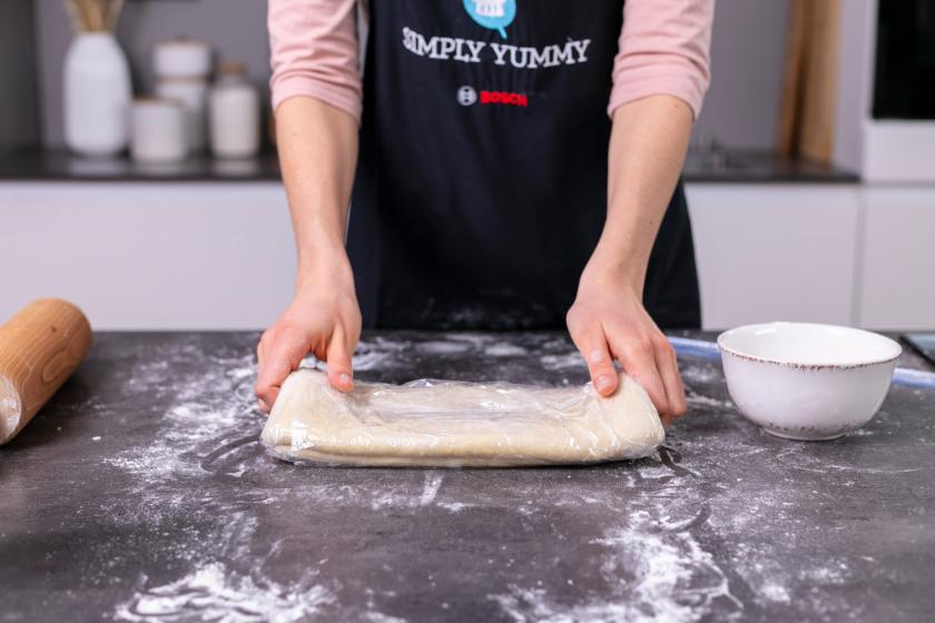 Croissant Teig wird in Folie eingeschlagen.