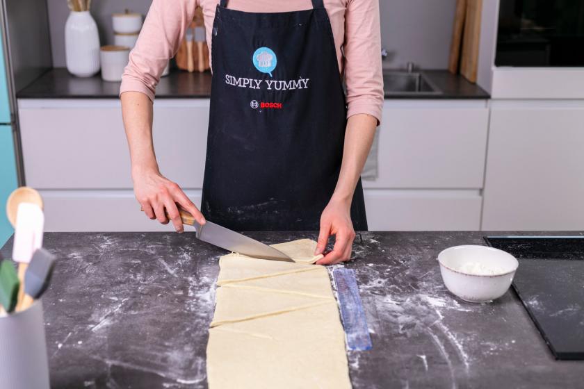 Croissant Teig wird in Dreiecke geschnitten.