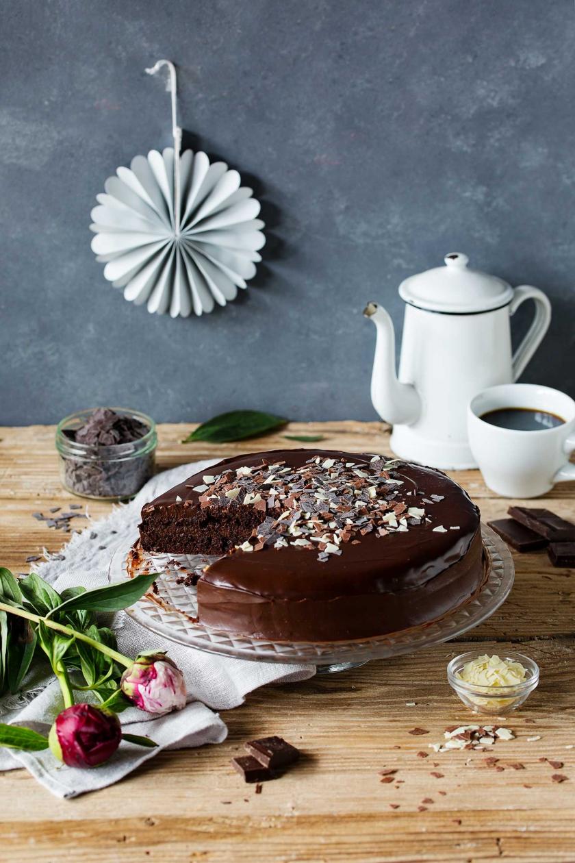 Death by Chocolate angeschnitten auf einer Kuchenplatte auf einem gedeckten Tisch.