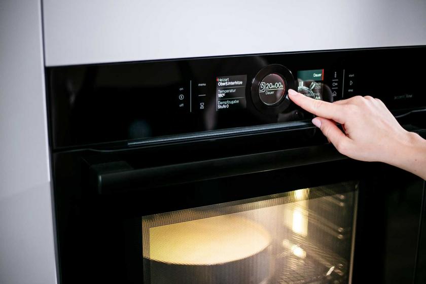 Der Timer am Backofen wird eingestellt.