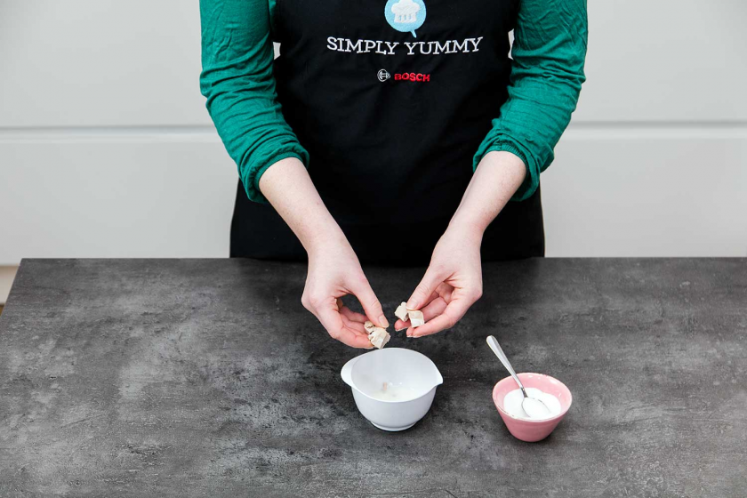 Hefe wird in Milch gebröselt für den Teig der Donuts.