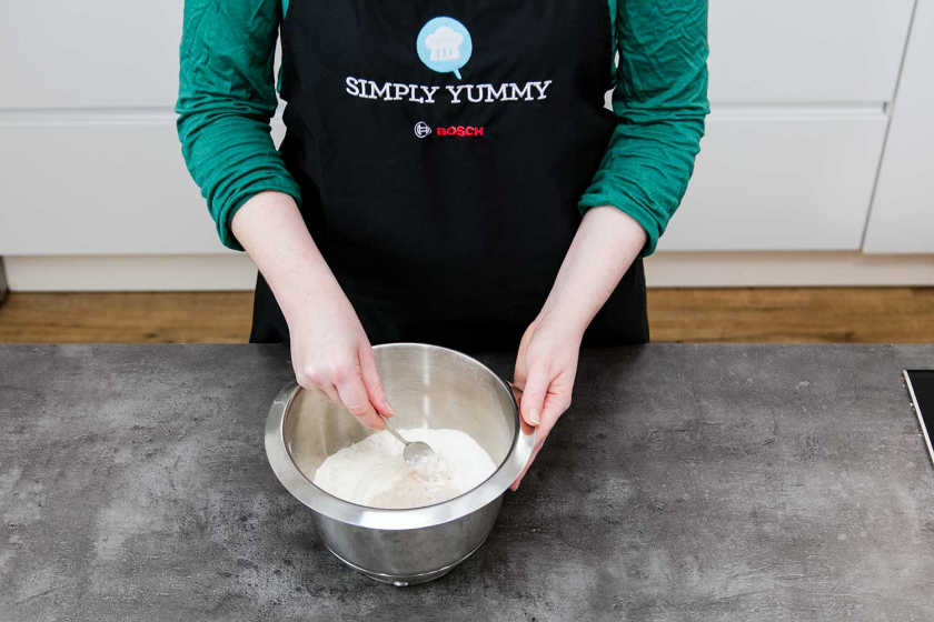 Für den Donut Teig wird Mehl zur Hefemischung gegeben.