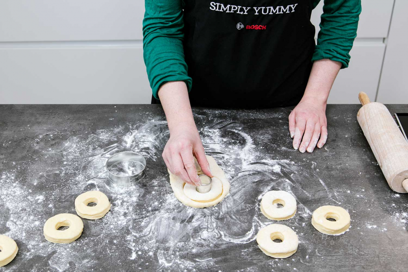 Aus dem Teig werden Donuts ausgestochen.