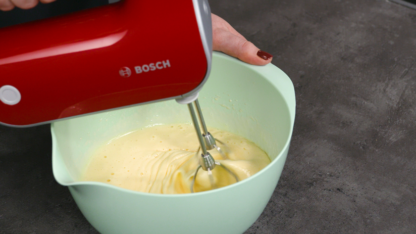 Die Zutaten für den Biskuitteig für den Eierlikör Drip Cake mit weißer Schokolade werden in einer Schüssel verrührt.
