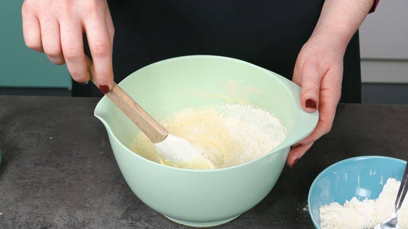 Die trockenen Zutaten für den Eierlikör Drip Cake mit weißer Schokolade werden unter die Eimasse gehoben.