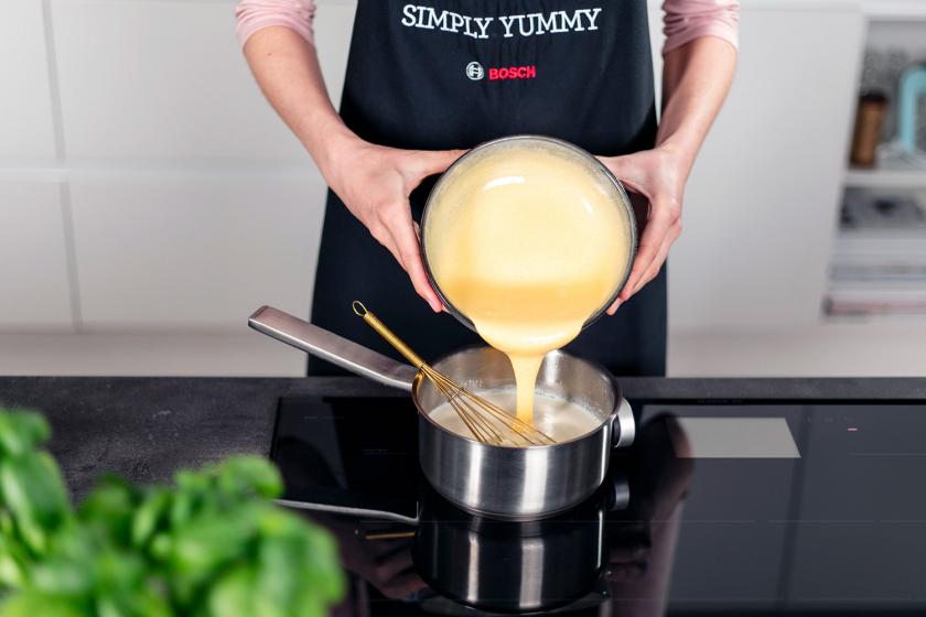 Eigelbmasse wird zur Sahnemischung in den Topf gegeben.