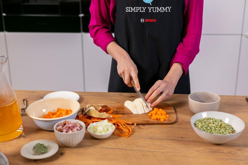 Knollensellerie wird auf einem Holzbrett geschnitten.