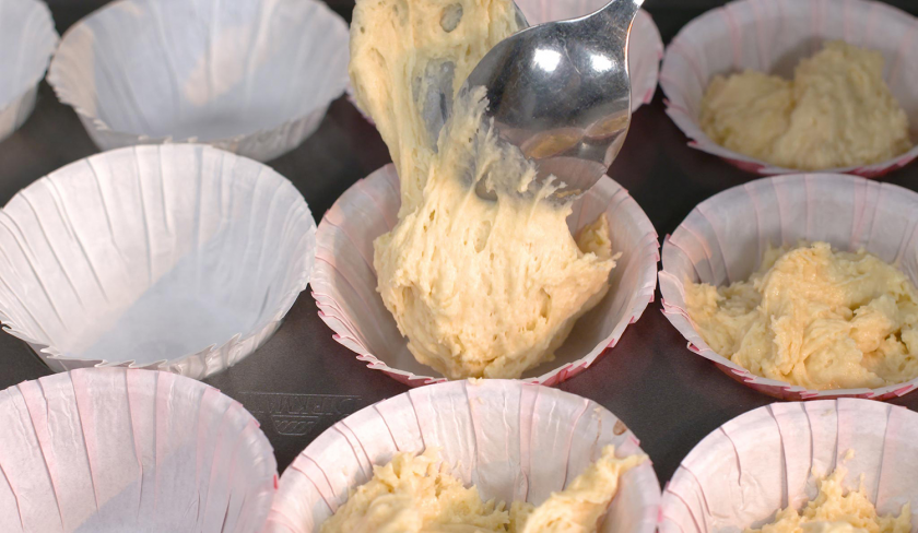 Der Teig für die Erdbeer-Muffins wird in Papierförmchen gegeben.