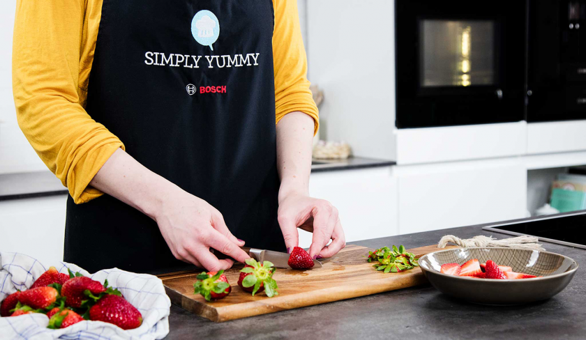 Erdbeeren für den Erdbeer-Rhabarber-Cobbler werden geschnitten.