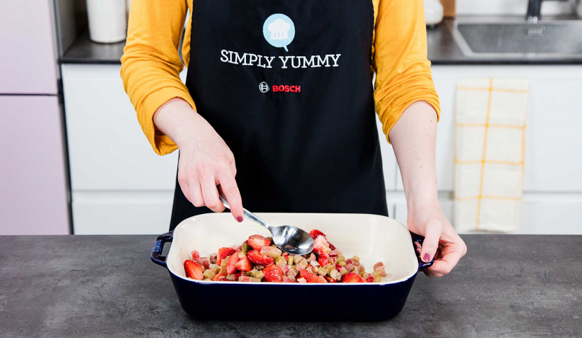 Die Füllung für den Erdbeer-Rhabarber-Cobbler wird in eine Auflaufform gegeben.