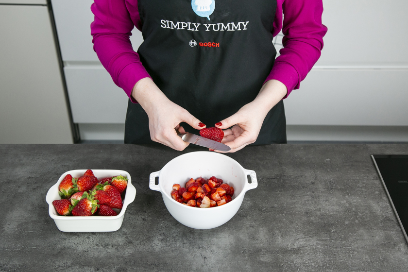 Für die Erdbeermarmelade werden Erdbeeren über einem Top klein geschnitten.