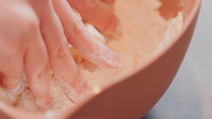 Der Teig für dir Erdbeerplunder wird mit den Fingern verknetet.