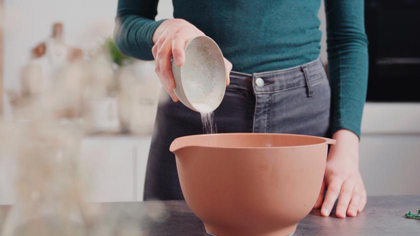 Zucker wird in eine Rührschüssel gegeben.