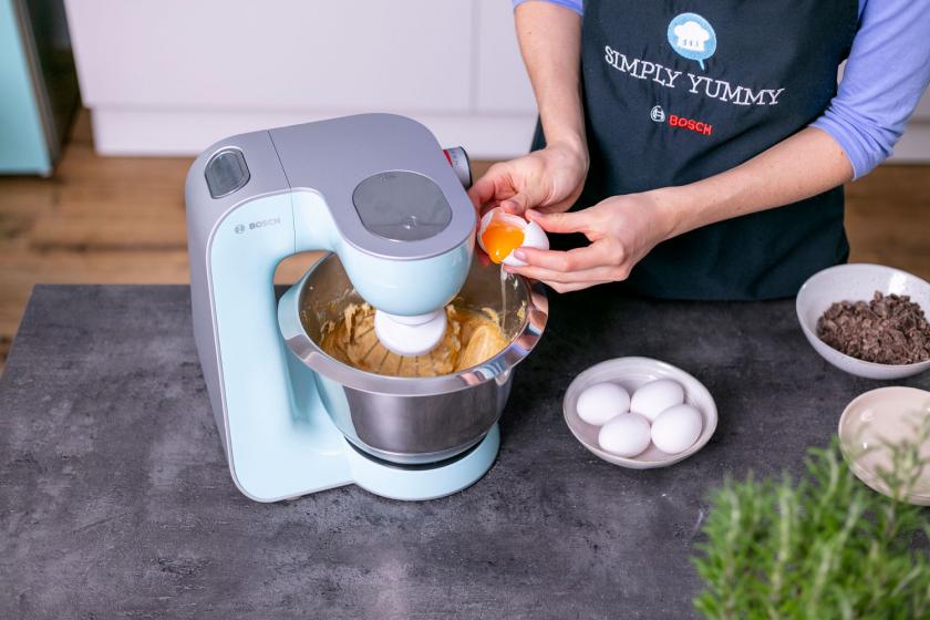 Eier werden zum Teig für den Erdnusskuchen gegeben.