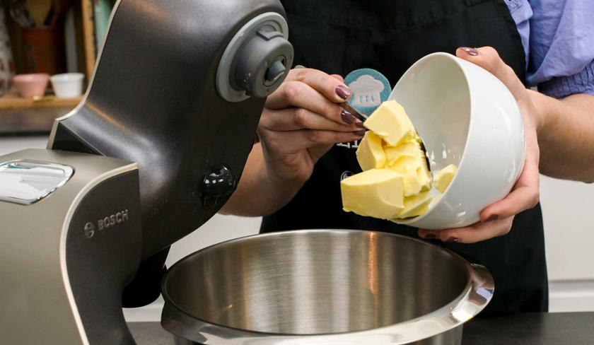 Für die Espresso-Muffins mit weißer Schokolade wird Butter in eine Rührschüssel gegeben.