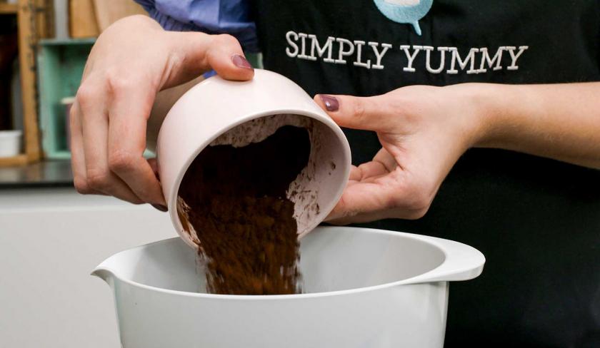 Für die Espresso-Muffins mit weißer Schokolade wird Kakao in eine Rührschüssel gegeben.