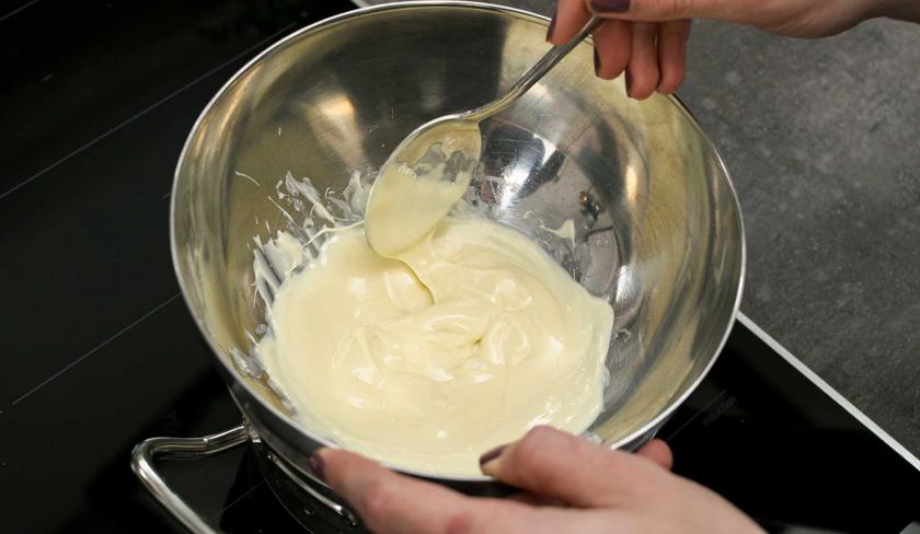 Für die Espresso-Muffins mit weißer Schokolade wird Schokolade in einem Wasserbad geschmolzen.