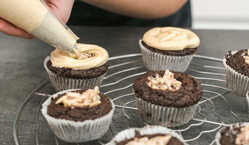 Die Espresso-Muffins mit weißer Schokolade werden mit Frosting bedeckt.
