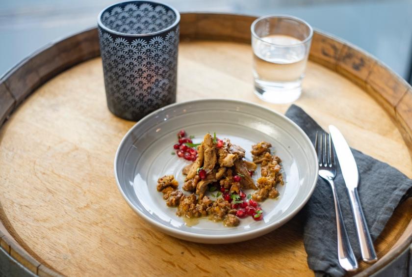 Fesenjan auf Teller auf Holztisch.