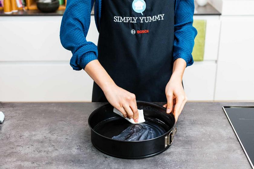 Eine Springform wird eingefettet.