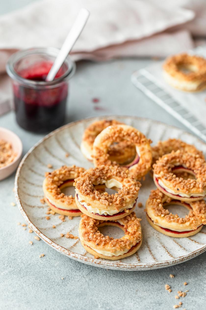 Frankfurter Kranz Plätzchen auf einem Teller, daneben Marmelade und Krokant auf einem Tisch