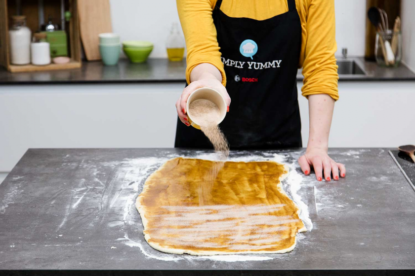 Der teig für die Franzbrötchen wird mit der Füllung bestreut.