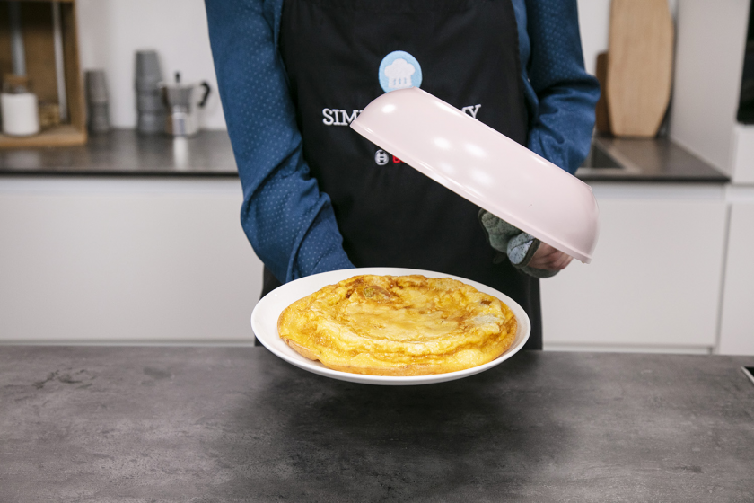 Frittata wird mithilfe eines Tellers gewendet.