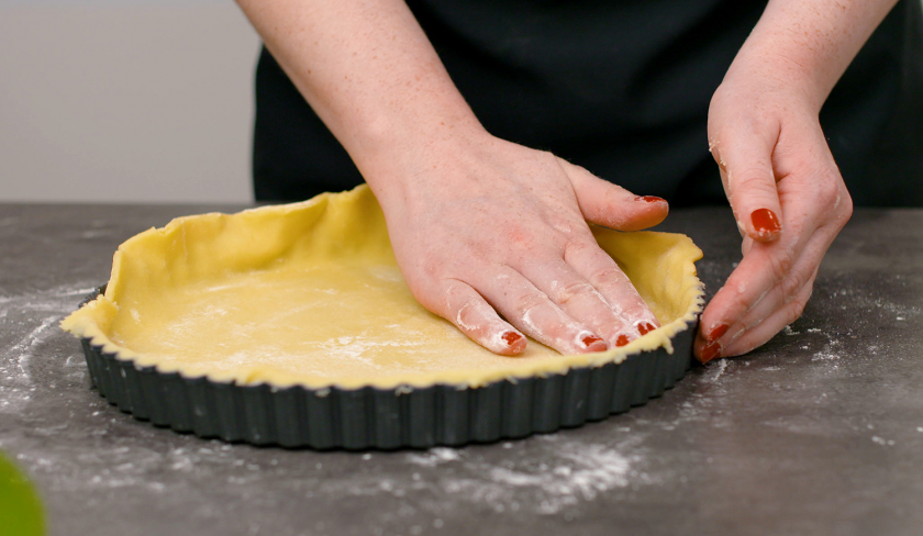 Der Boden für fruchtiger Mosaik Kuchen wird in die Form gelegt.