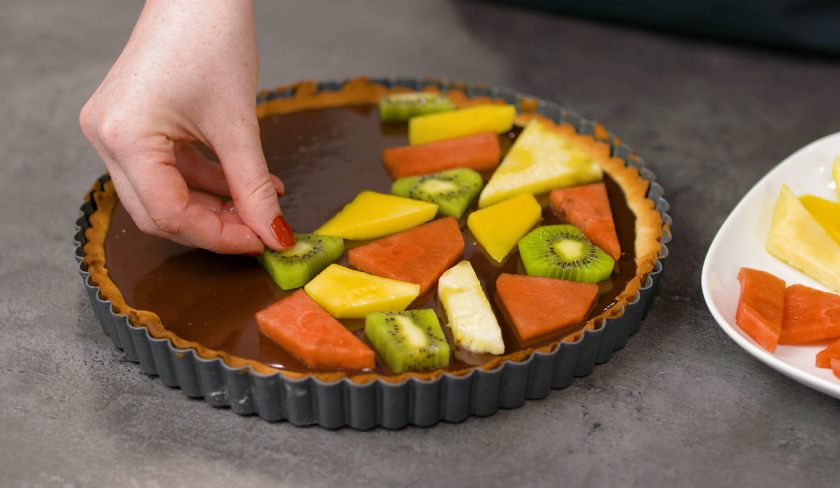 Die Obststücke werden auf der Ganache verteilt und ergeben fruchtiger Mosaik Kuchen.