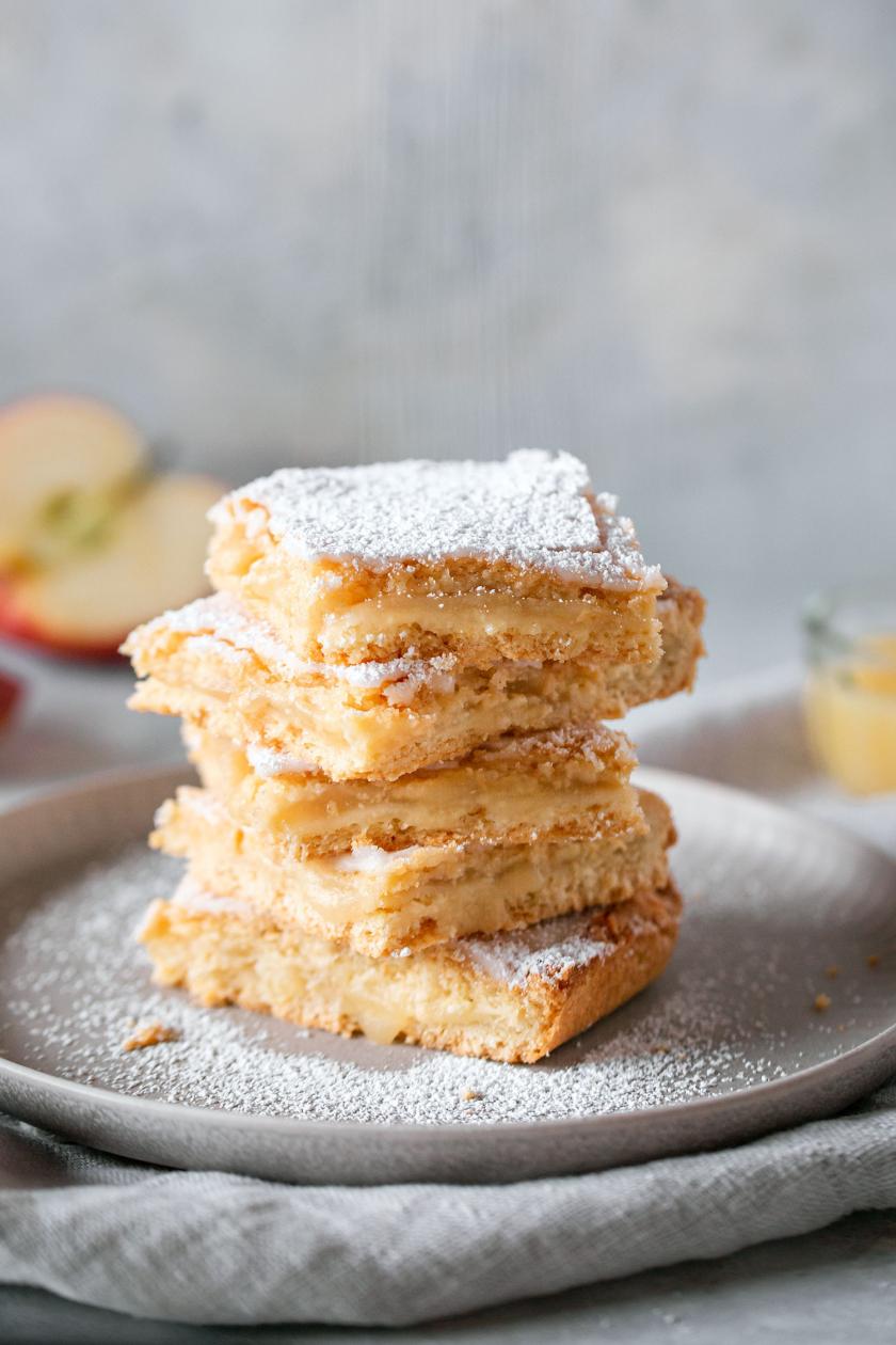 Gedecket Apfelmuskuchen vom Blech übereinandergestapelt.