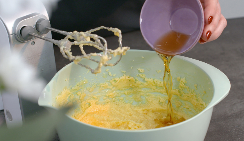 Für gefüllter Schoko-Erdbeerkuchen wird Rum in die Rhrschüssel mit Teig gegeben.