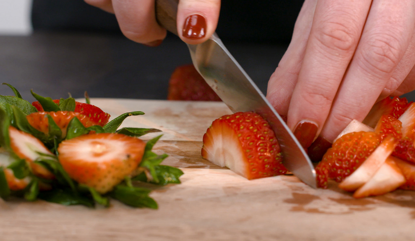 Für gefüllter Schoko-Erdbeerkuchen werden frische Erdbeeren geschnitten.
