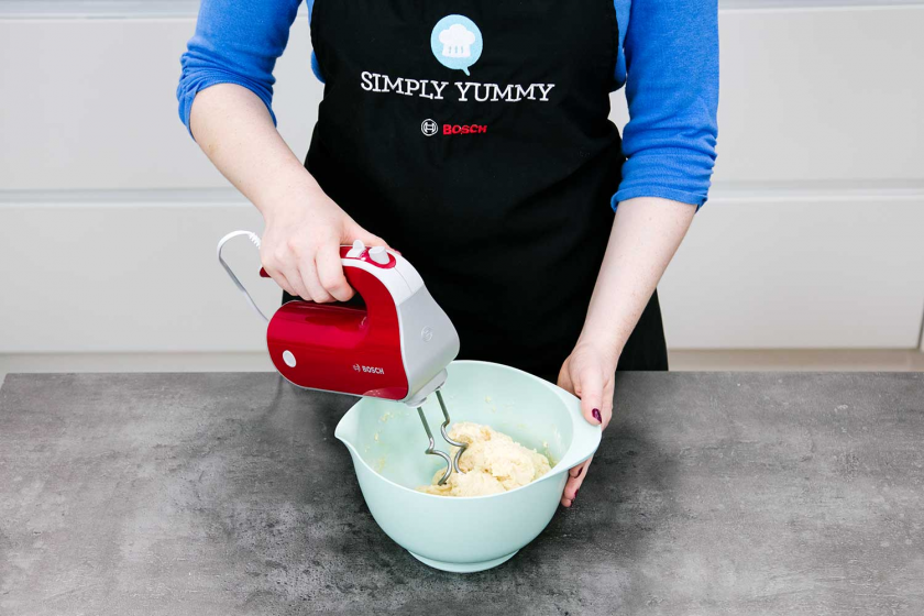 Für Germknödel wird ein Hefeteig mit einem Handrührgerät in einer Schüssel geknetet.
