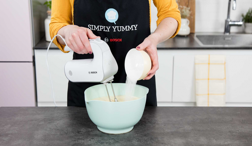Für die Giotto Torte werden Eier mit Zucker in einer Schüssel mit einem Handmixer schaumig geschlagen.