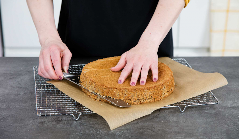 Für die Schichten der Giotto Torte wird der Biskuitboden mit einem Messer zerteilt.