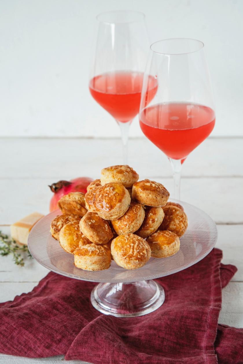 Scones auf Tortenplatte mit zwei Gläsern Granatapfel-Sprizz