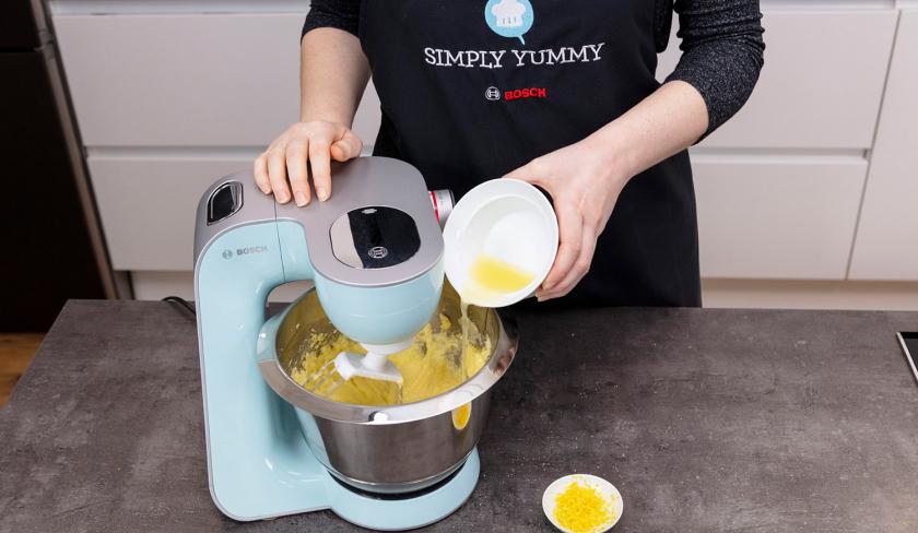Zum Teig für den Grießkuchen wird Zitronensaft in die Rührschüssel der Küchenmaschine gegeben.