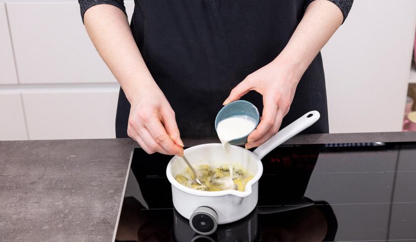 Damit das Kiwikompott für den Grießkuchen bindet, wird Stärke dazugegeben und eingerührt.