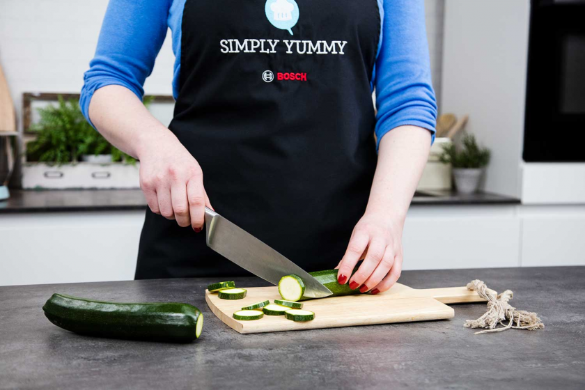 Für die grüne Buddha Bowl wird Zucchini geschnitten.
