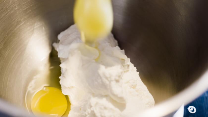 Für den Teig des Haferflockenbrots mit Quark werden Eier und Quark in einer Rührschüssel verrührt.