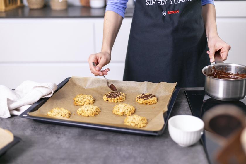 Haferflockenkekse ohne Zucker werden mit Zartbitterschokolade dekoriert.