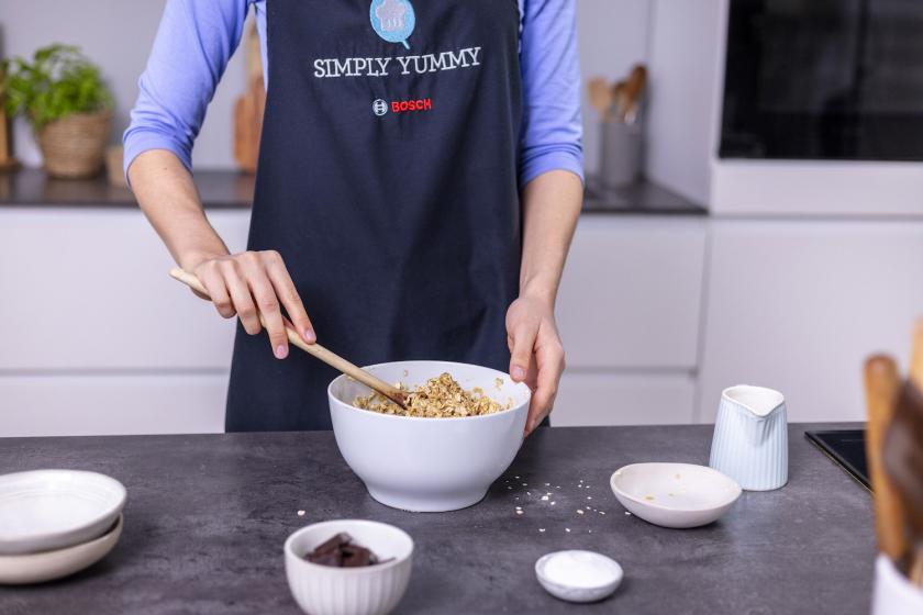 Der Teig für die Haferflockenkekse ohne Zucker wird mit einem Holzlöffel verrührt.