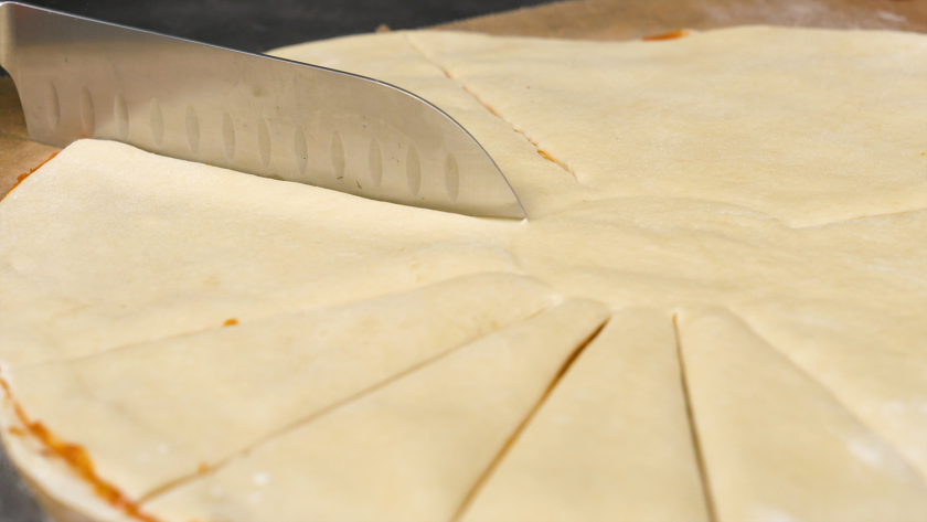 Der Teig für die Hefeblume mit rotem Pesto wird in 16 Streifen geschnitten.