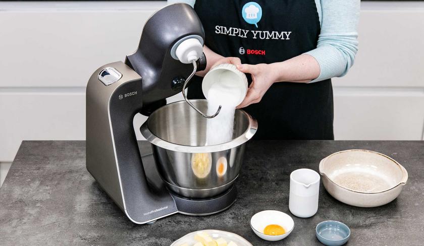 Zucker wird in die Rührschüssel einer Küchenmaschine gegeben.