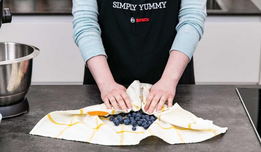 Heidelbeeren werden auf einem Küchentuch abgetrocknet.