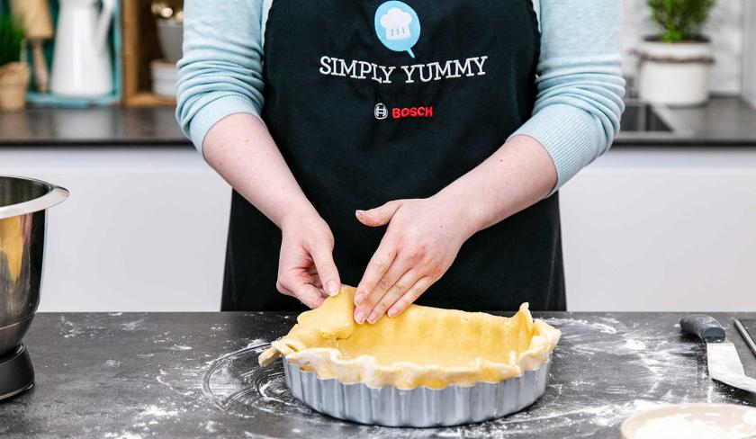 Der Teig für den Heidelbeerkuchen mit Schmand wird in die Form eingepasst.