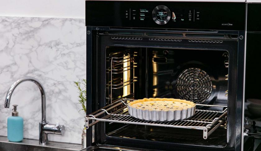 Der Heidelbeerkuchen mit Schmand steht auf dem Rost im Backofen.