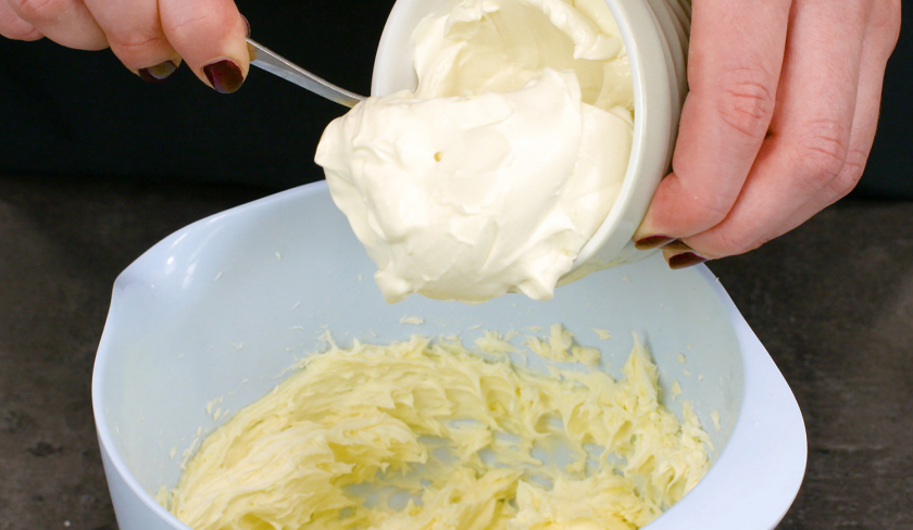 Für das Frosting der Hexen-Cupcakes für Halloween wird Frischkäse zur Butter in eine Schüssel gegeben.